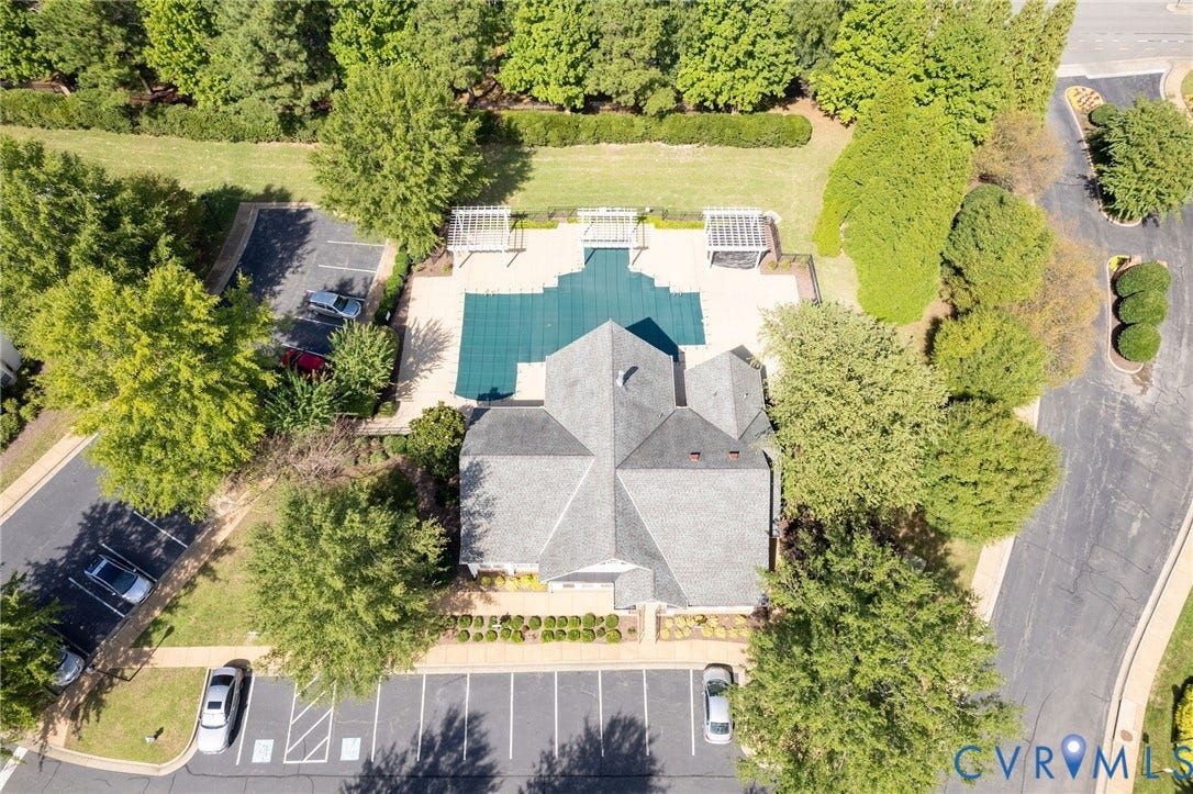 Swimming pool with a cover, two poolside pergolas, and surrounding paved patio