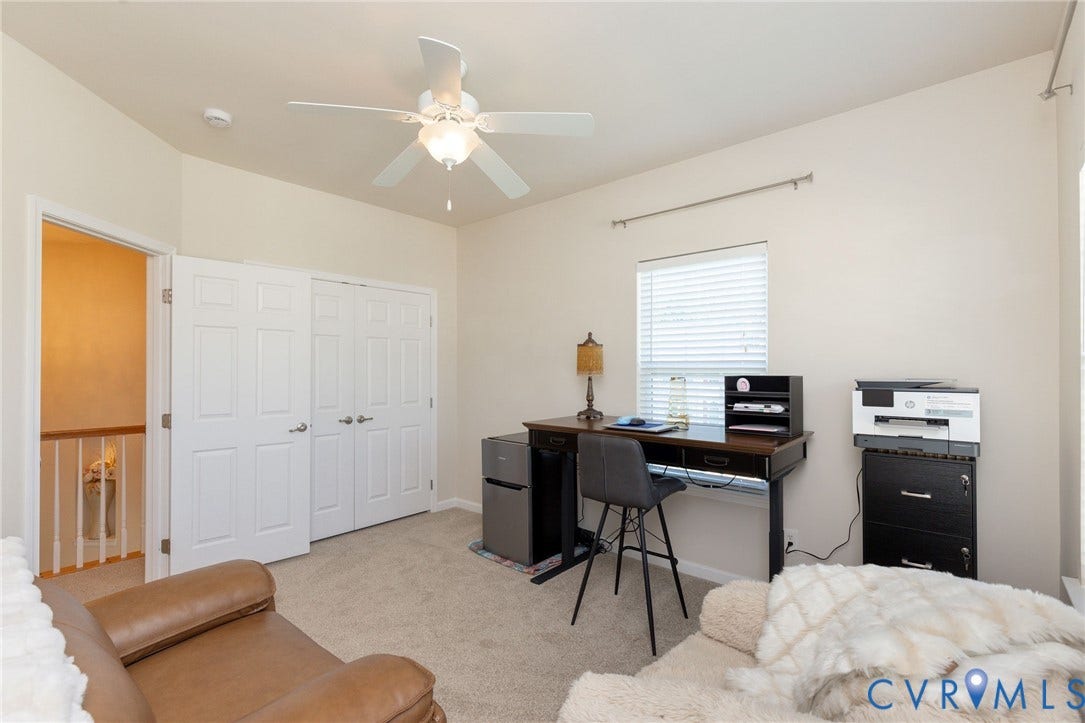 Neutral wall paint, ceiling fan, carpeted flooring, and a large window with blinds