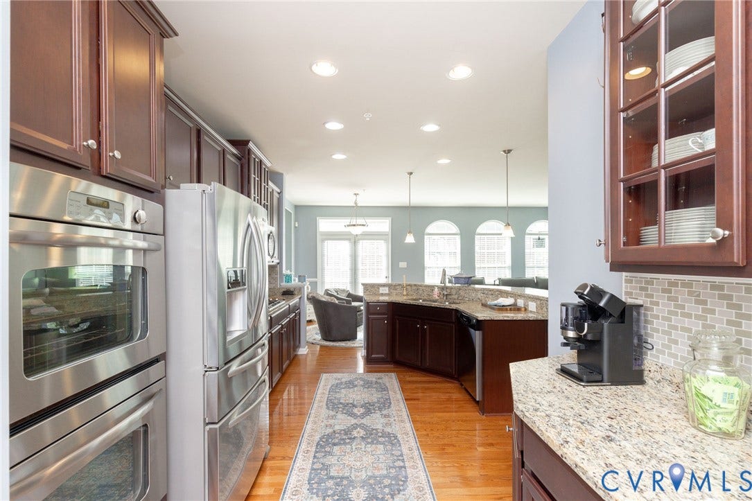 Kitchen featuring wood-finish flooring, recessed lighting, and built-in stainless steel appliances