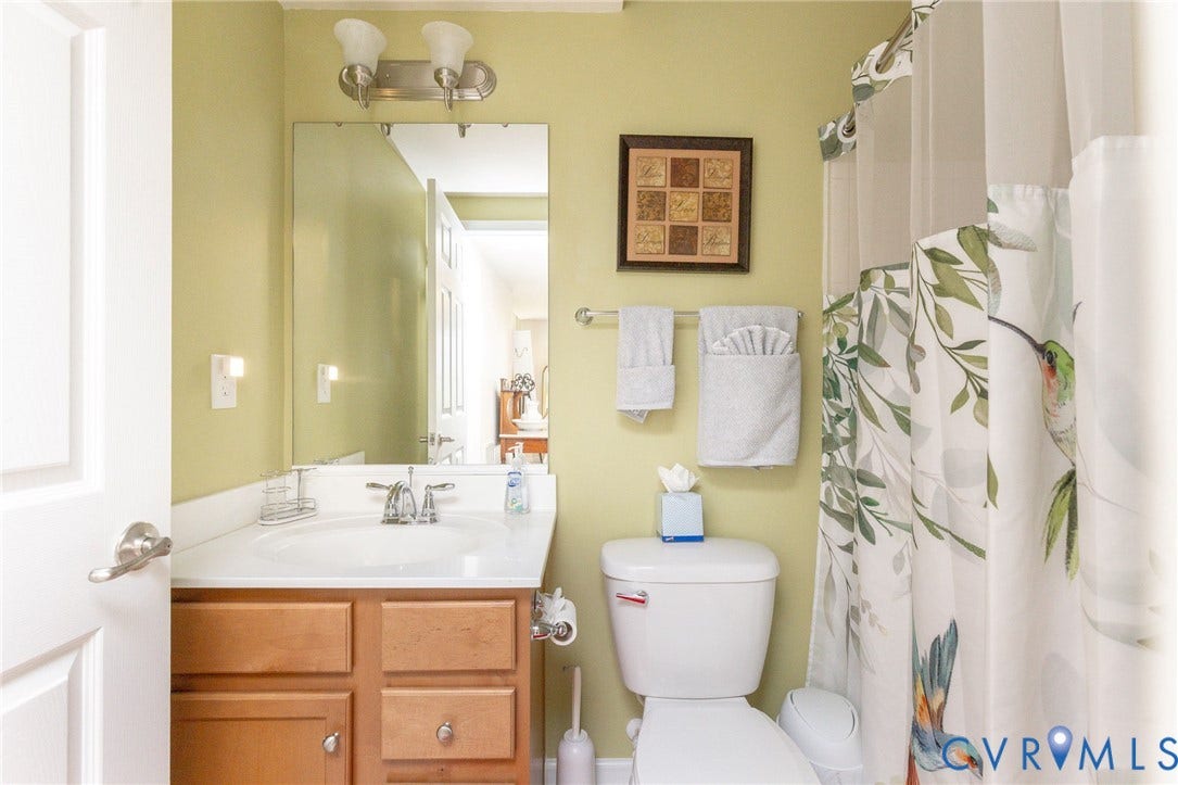 Vanity with an integrated white sink, chrome faucet, and wood-finish cabinetry