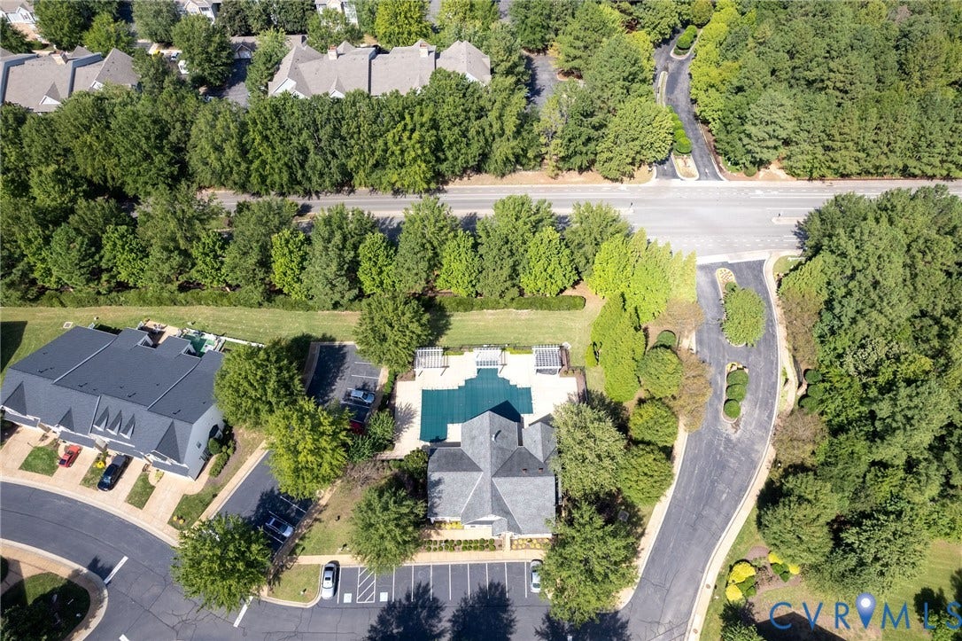 Community features a swimming pool, multiple structures with dark gray roofs, and ample surface parking