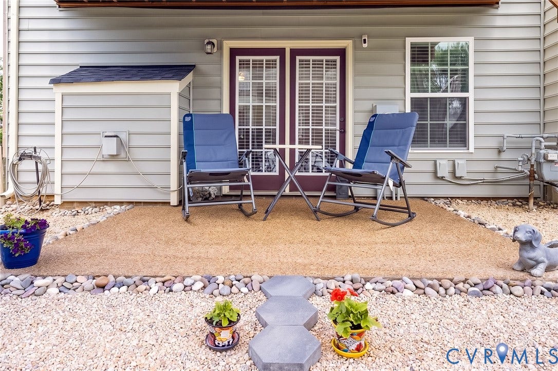 Patio with french doors, gravel landscaping, built-in storage shed, and a privacy window