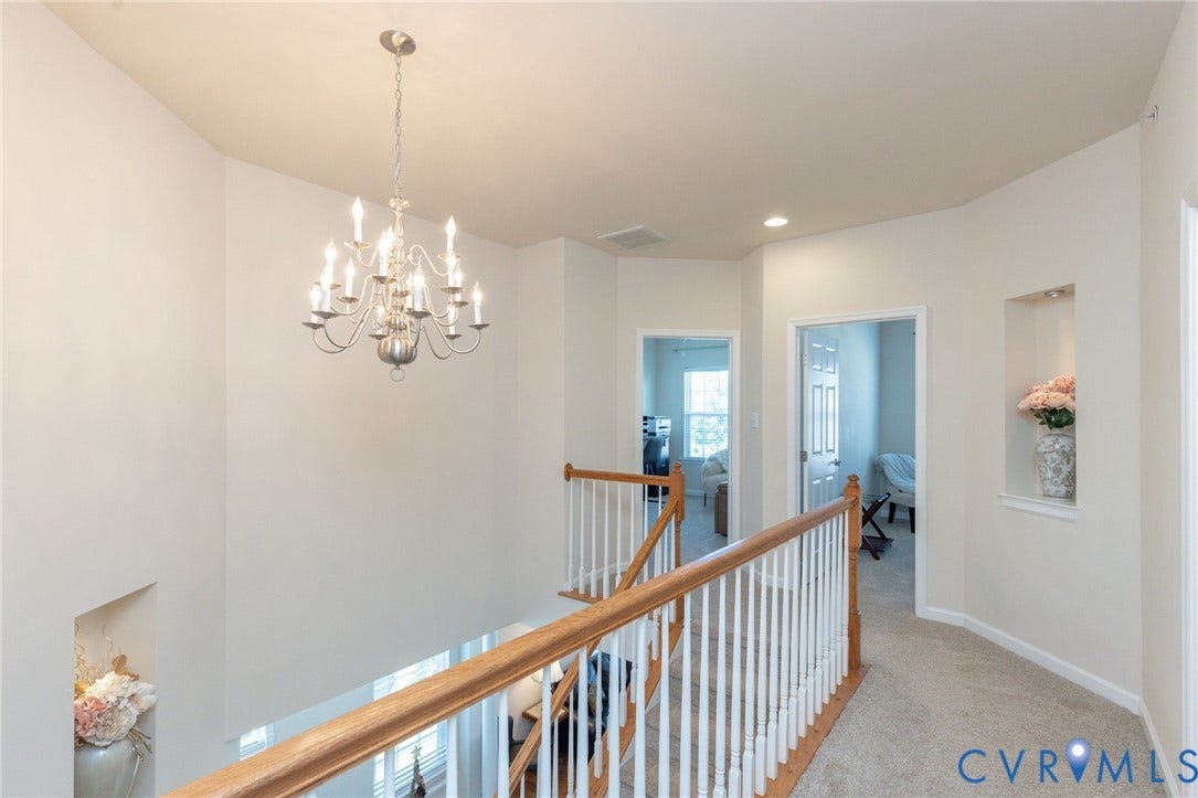 Two-story foyer with a decorative chandelier, recessed lighting, and built-in wall niches