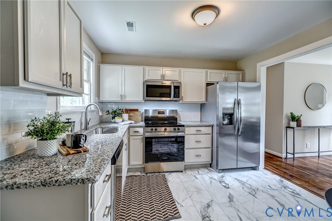 Tile subway splash, new stainless appliances, sleek granite tops, marble-esque tile floor...