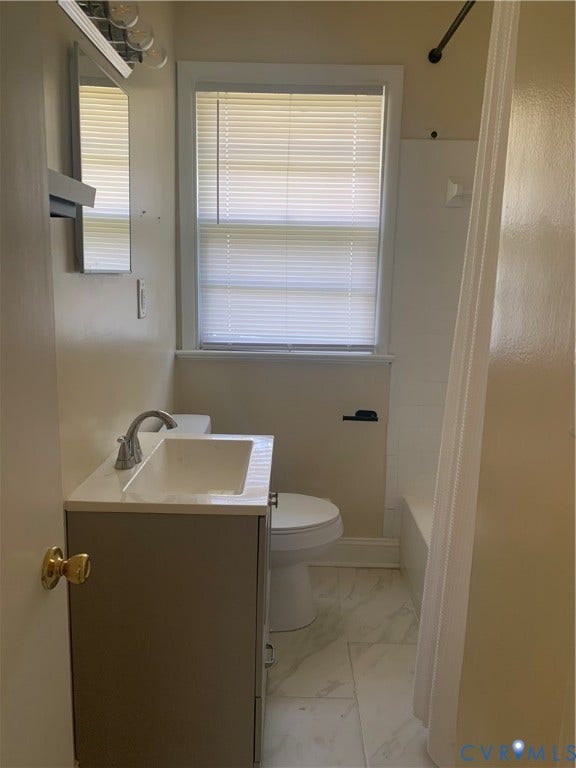 Vanity with an integrated sink, polished chrome faucet, and under-sink storage