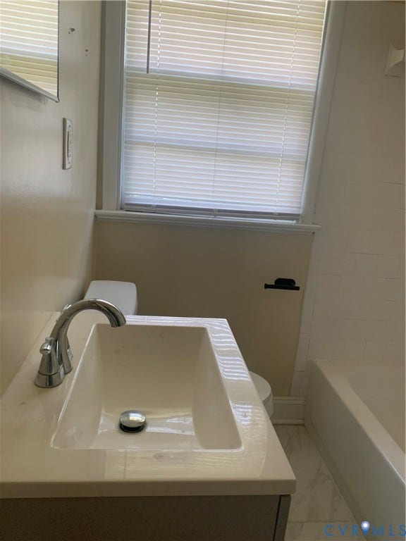Integrated vanity with single basin sink, chrome faucet, and white countertop