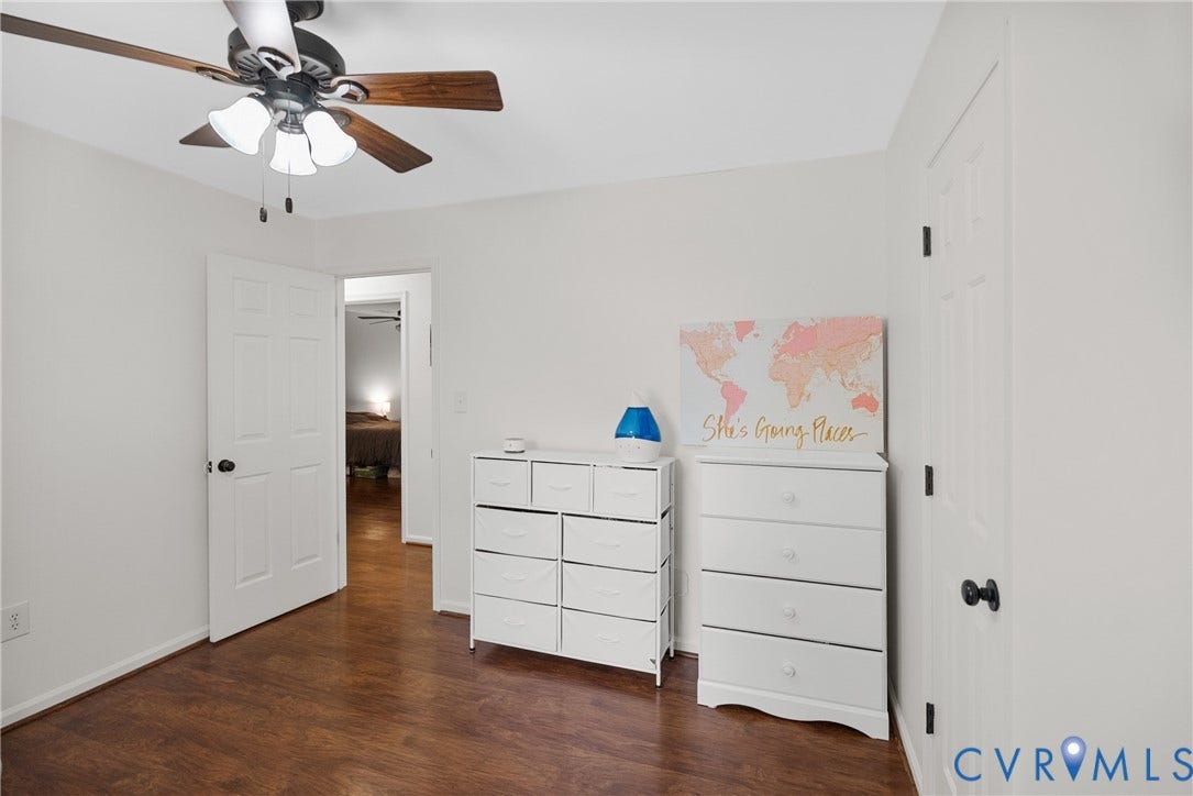 Wood-finish flooring, white paneled doors, ceiling fan with integrated lighting, and white walls