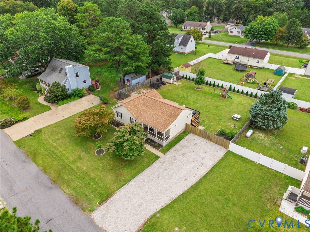 Single-story residence with a pitched roof, screened porch, and gravel driveway
