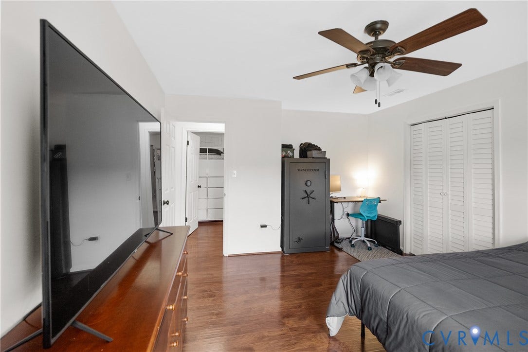 Wood-finish flooring throughout, ceiling fan with integrated lighting, and white bi-fold closet doors