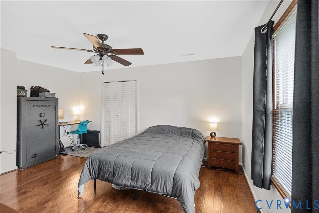 Wood-finish flooring, white walls, and a ceiling fan with integrated lighting