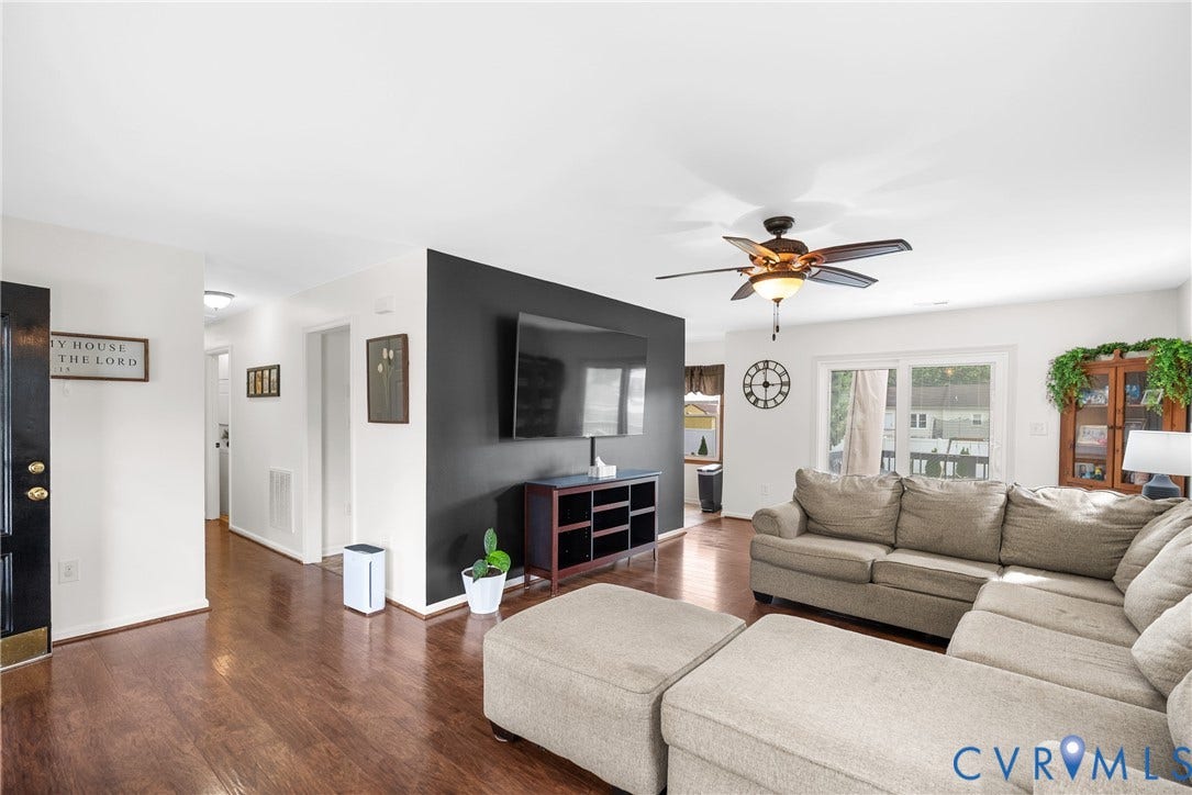 Hardwood-finish flooring throughout, ceiling fan with integrated lighting, sliding glass door, and a built-in entertainment console