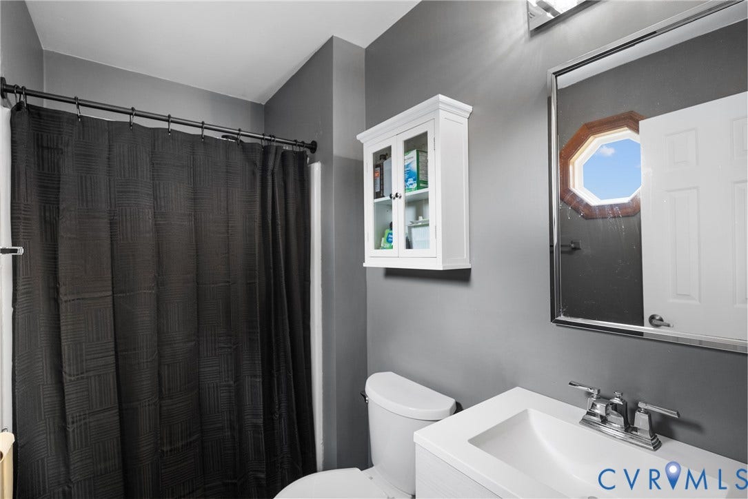 Single vanity with integrated sink, chrome faucet, and a wall-mounted medicine cabinet