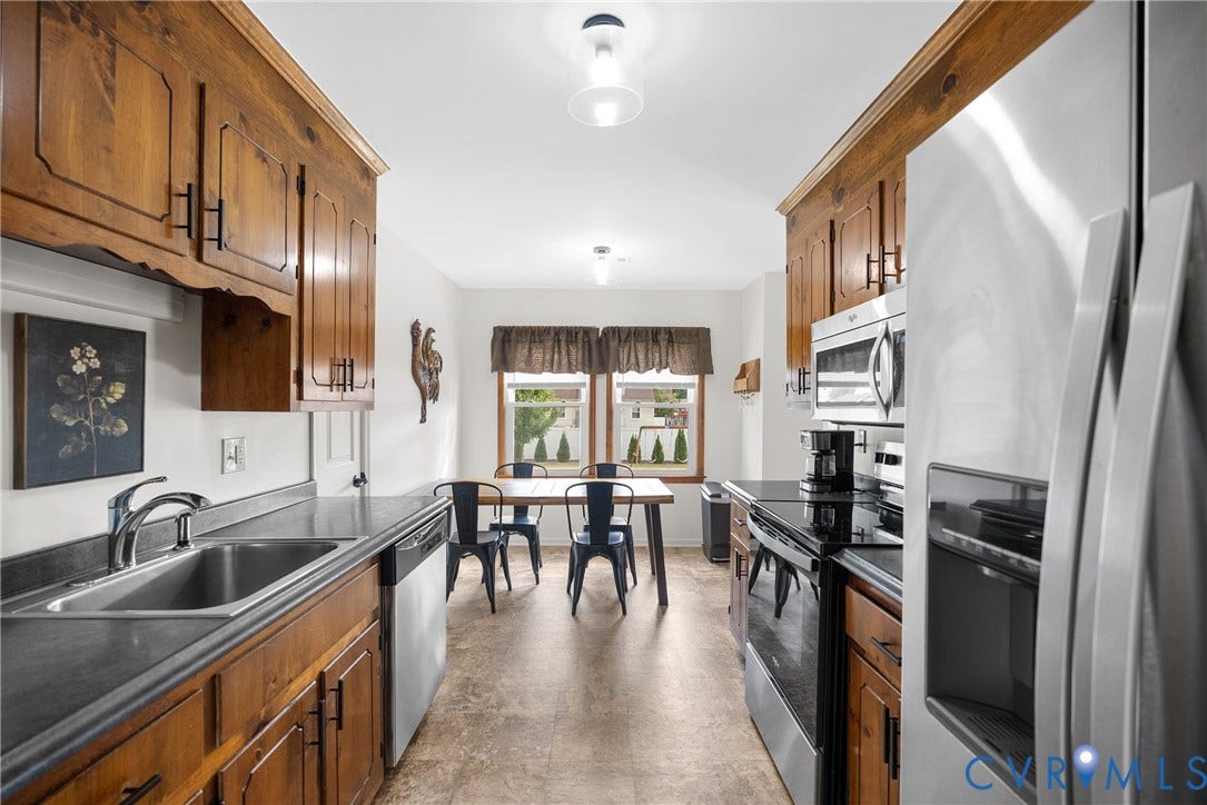 Kitchen featuring wood cabinetry, stainless steel appliances, and a double basin sink