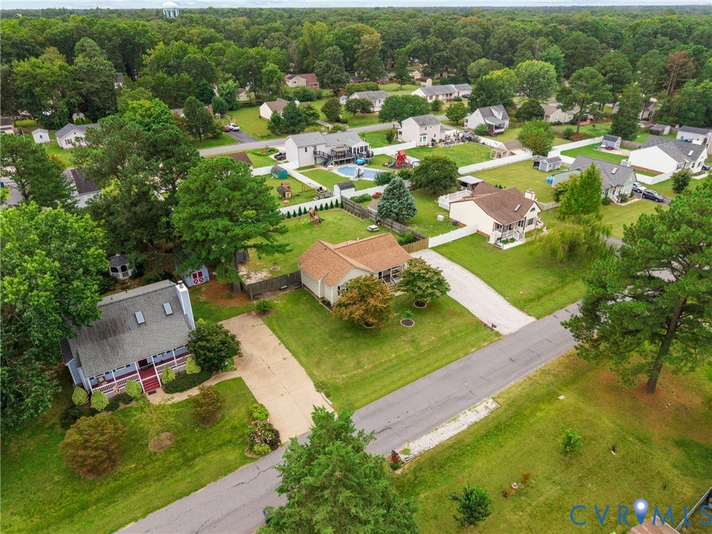 Aerial perspective of a residential neighborhood with mature trees and detached homes