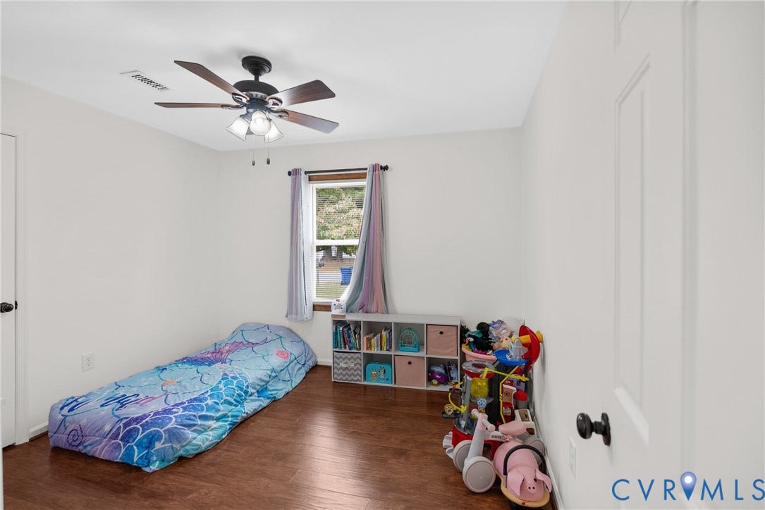 Wood-finish flooring, white walls, and a ceiling fan with integrated lighting