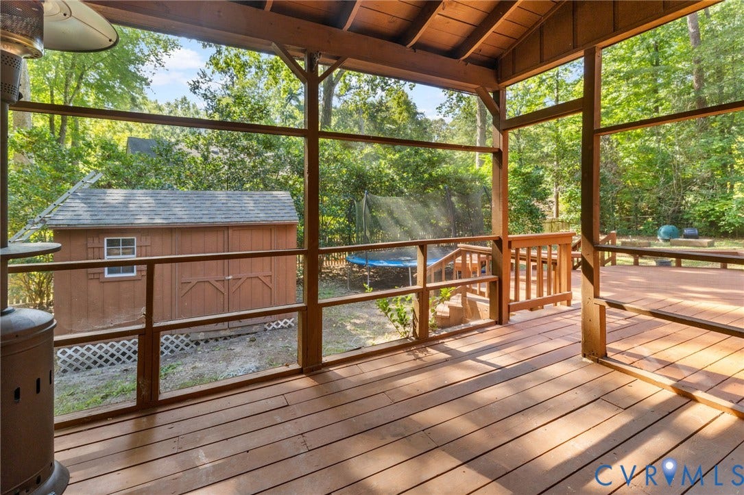 Screened porch with wood flooring, wood railing, wood ceiling, and a detached wood shed with a shingle roof