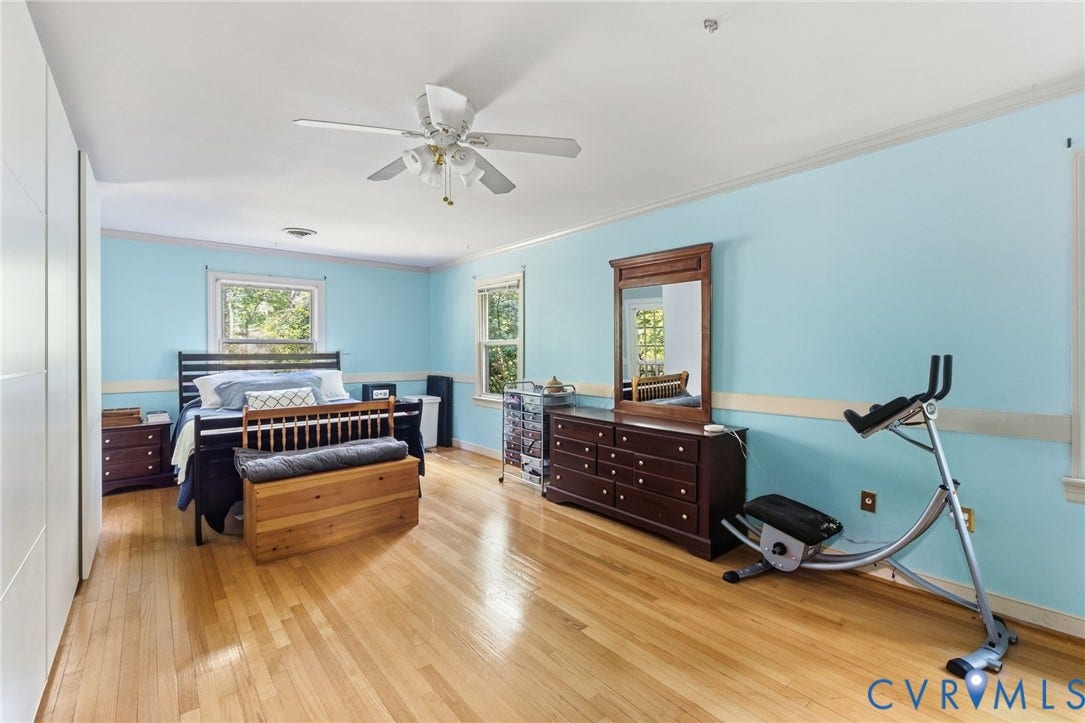 The primary bedroom is accented with crown moulding, chair rail ceiling fan, and wood floor.