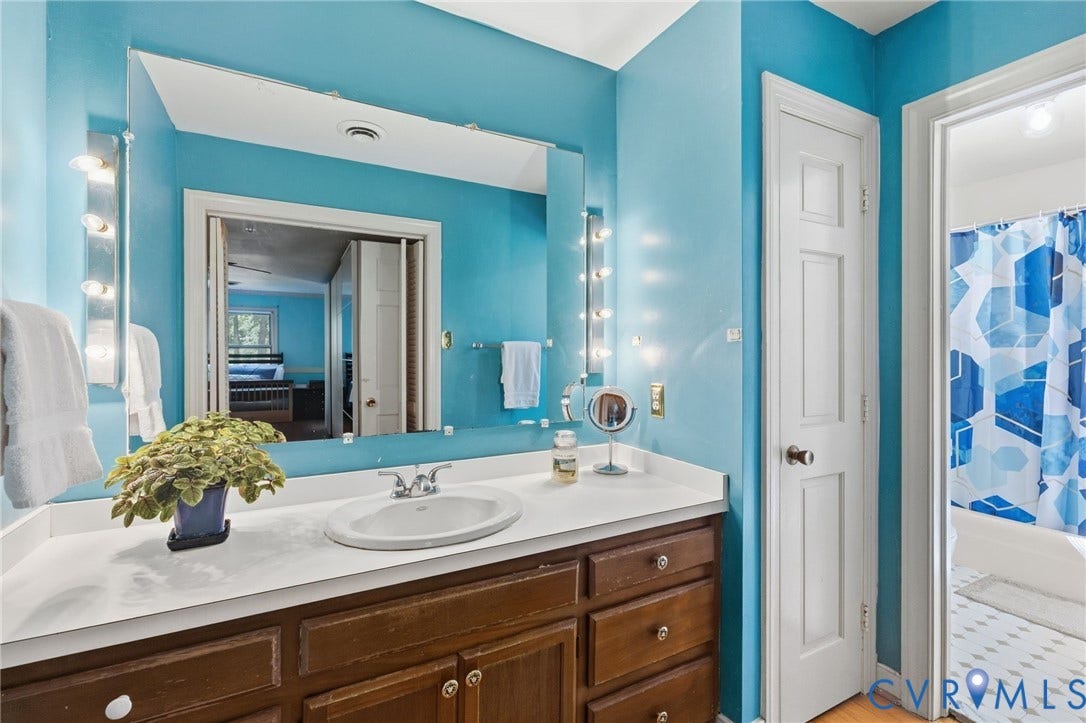 Primary bath separated with vanity,  sink and linen closet in one area and the other room has tile floor, tub,sink, and toilet.