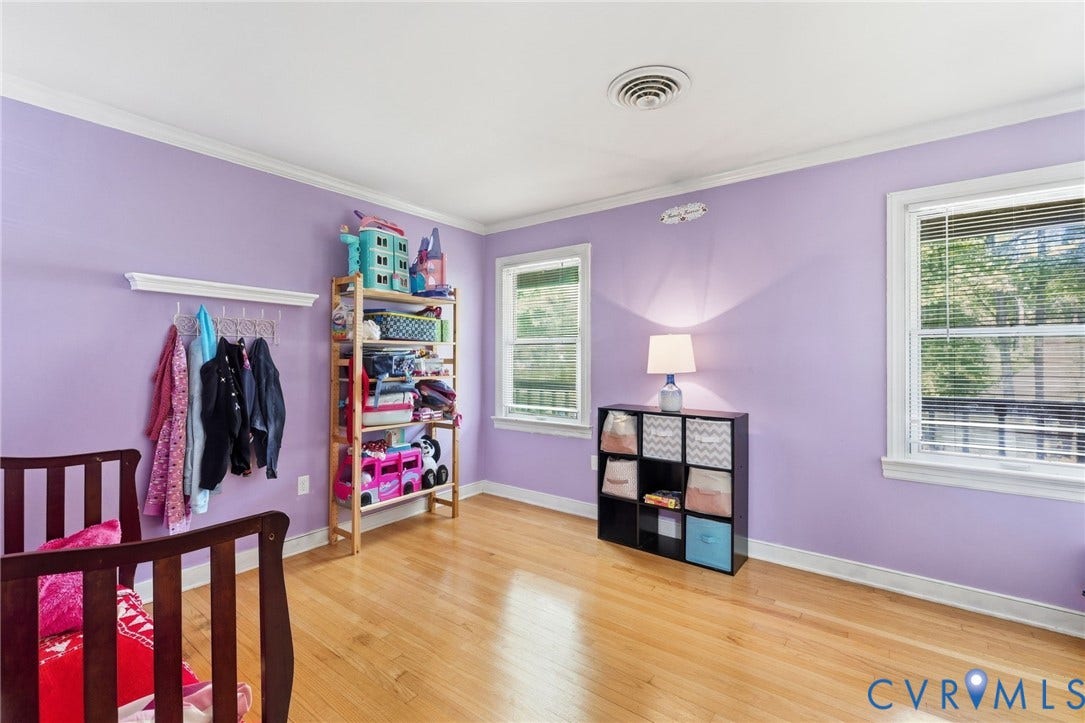Hardwood flooring, crown molding, two windows with blinds, and walk up attic.