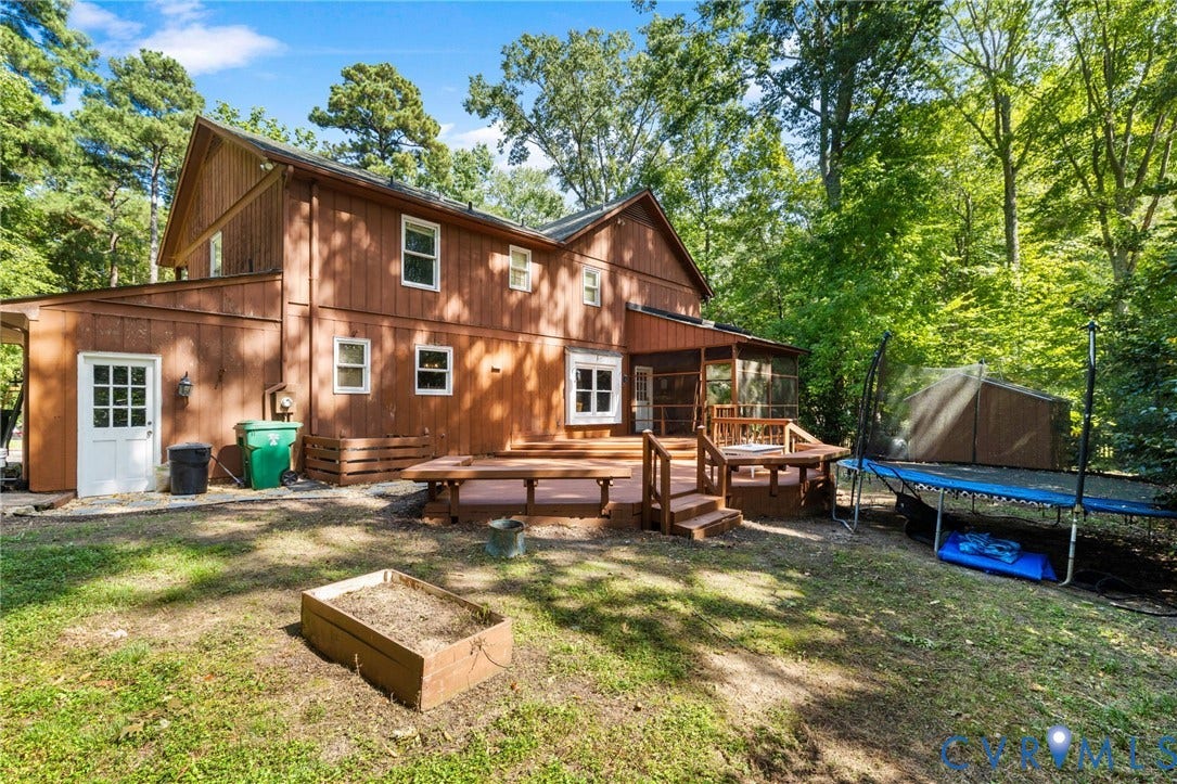 Wood-sided exterior featuring multiple windows, a raised multi-level wood deck, a screened porch, and a wood storage shed