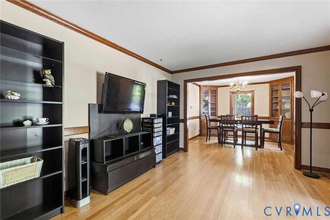 Hardwood flooring throughout, crown molding, and a wide cased opening