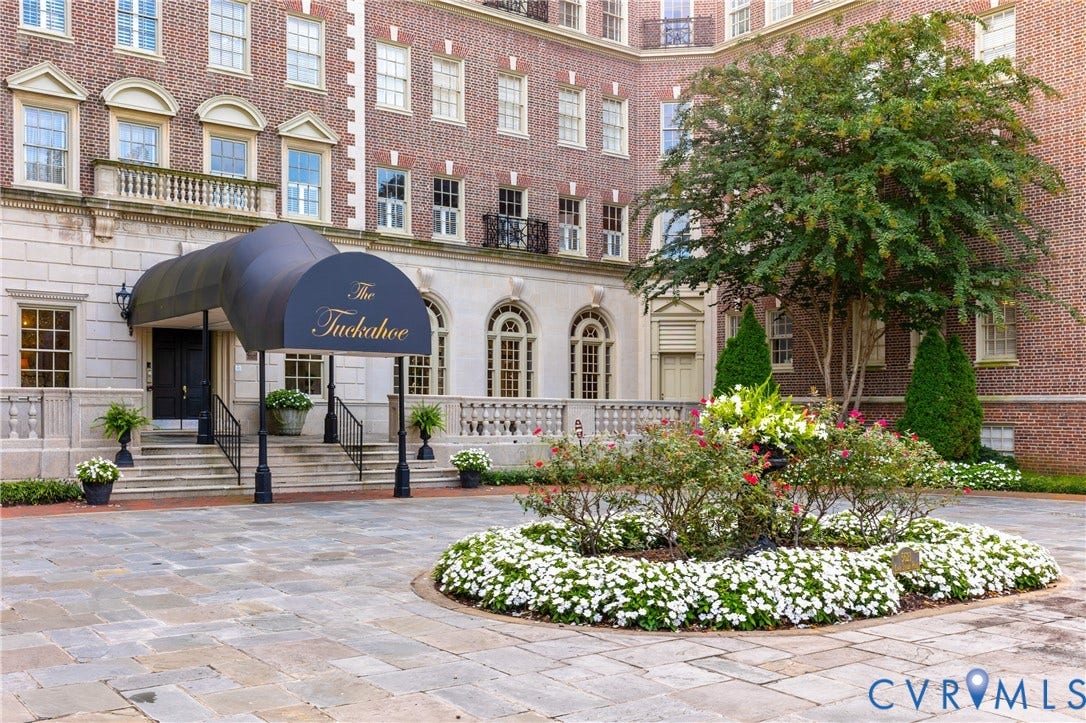 5621 Cary Street Road, #U4, Wilton, Richmond, VA 23226 Classic brick exterior featuring a covered entryway with a decorative canopy, stone-paved motor court, stone balustrades, and a central landscaped garden bed
