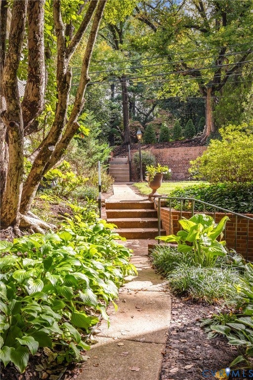 5621 Cary Street Road, #U4, Wilton, Richmond, VA 23226 Landscaped garden path featuring brick retaining walls, concrete stairs with metal railings, mature trees, and perennial plantings