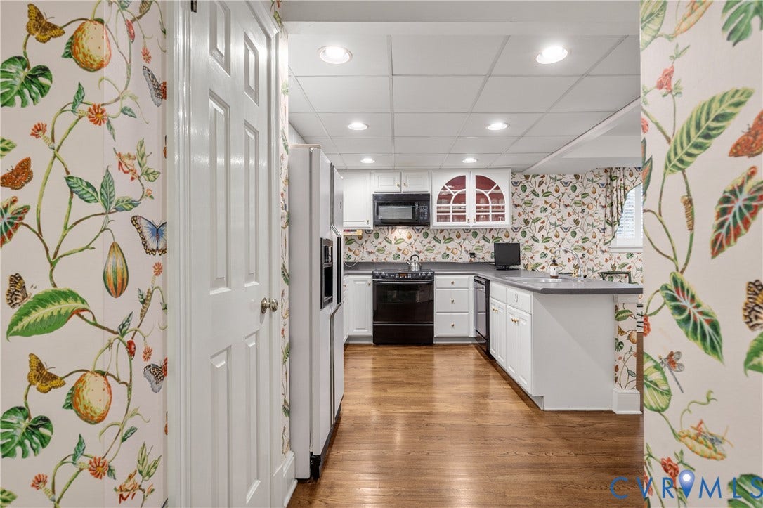 5621 Cary Street Road, #U4, Wilton, Richmond, VA 23226 Kitchen featuring wood-finish flooring, white cabinetry with glass-front display accents, integrated black appliances, and a peninsula with countertop space