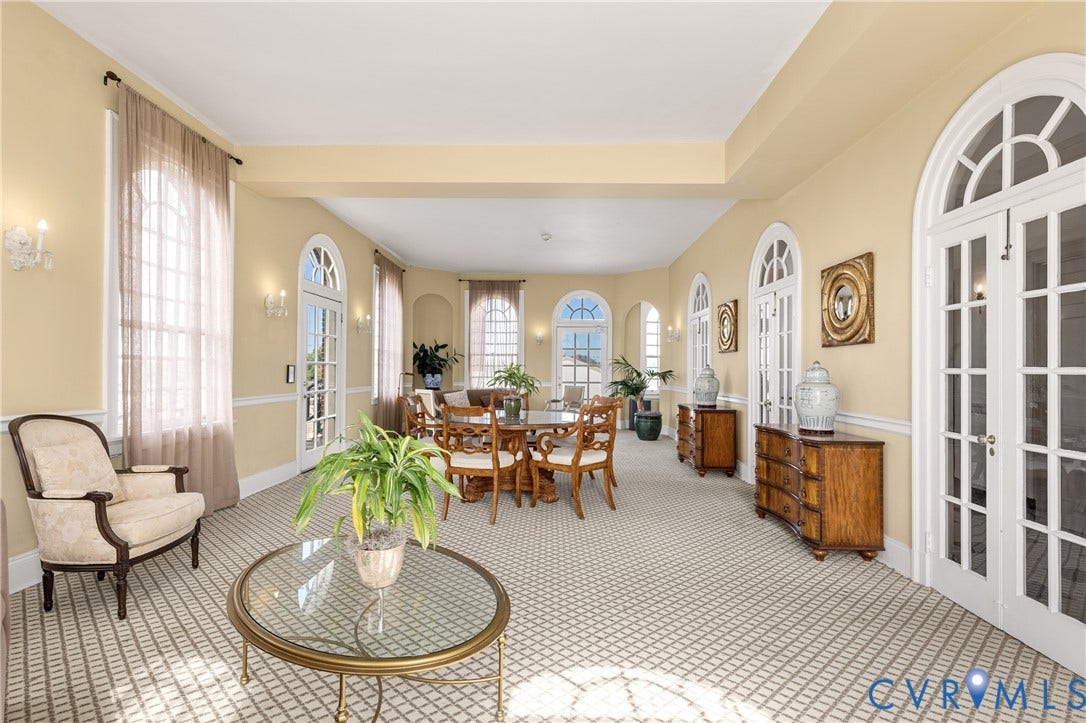 5621 Cary Street Road, #U4, Wilton, Richmond, VA 23226 Expansive room featuring multi-pane arched windows, French door access, integrated wall niches, crown molding, and wall-mounted light fixtures