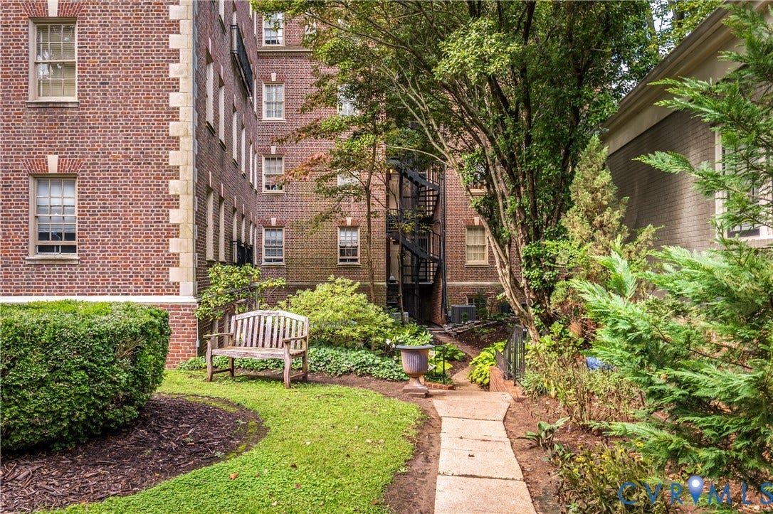 5621 Cary Street Road, #U4, Wilton, Richmond, VA 23226 Classic red brick facade with stone quoins, manicured lawn, flagstone pathway, mature landscaping, and an iron spiral staircase