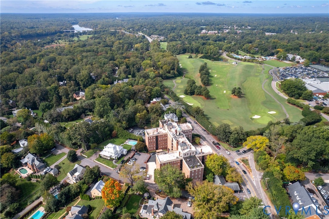 5621 Cary Street Road, #U4, Wilton, Richmond, VA 23226 Aerial perspective of a multi-story brick building situated amidst extensive wooded acreage, featuring proximity to an expansive golf course and surrounding mature tree canopy