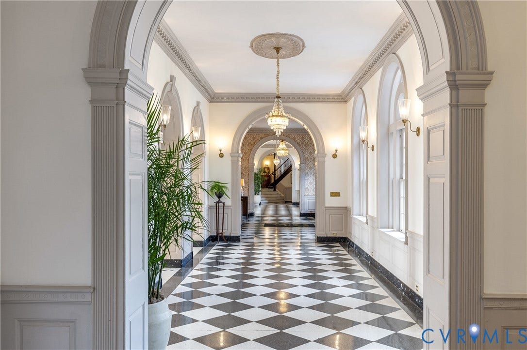 5621 Cary Street Road, #U4, Wilton, Richmond, VA 23226 Grand hallway featuring arched entryways, checkerboard tile flooring, detailed crown molding, wainscoting, and crystal chandeliers