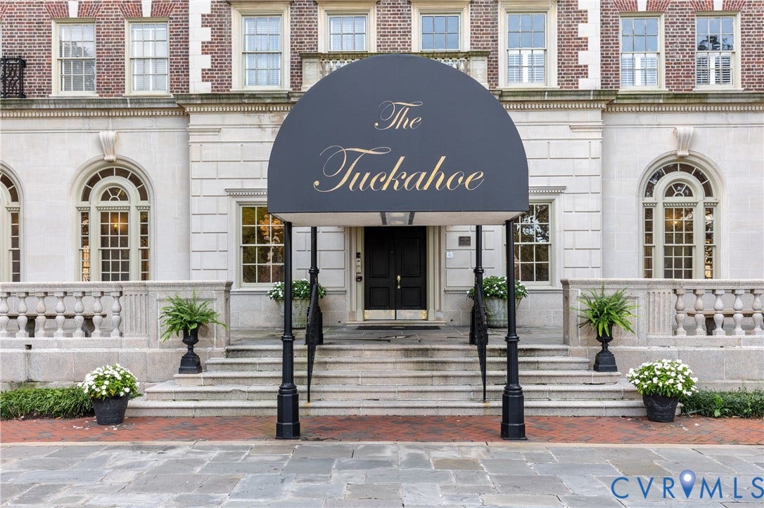 5621 Cary Street Road, #U4, Wilton, Richmond, VA 23226 Classical stone facade featuring arched window casings, decorative balustrade railings, multi-pane windows, and a covered entryway with a metal canopy