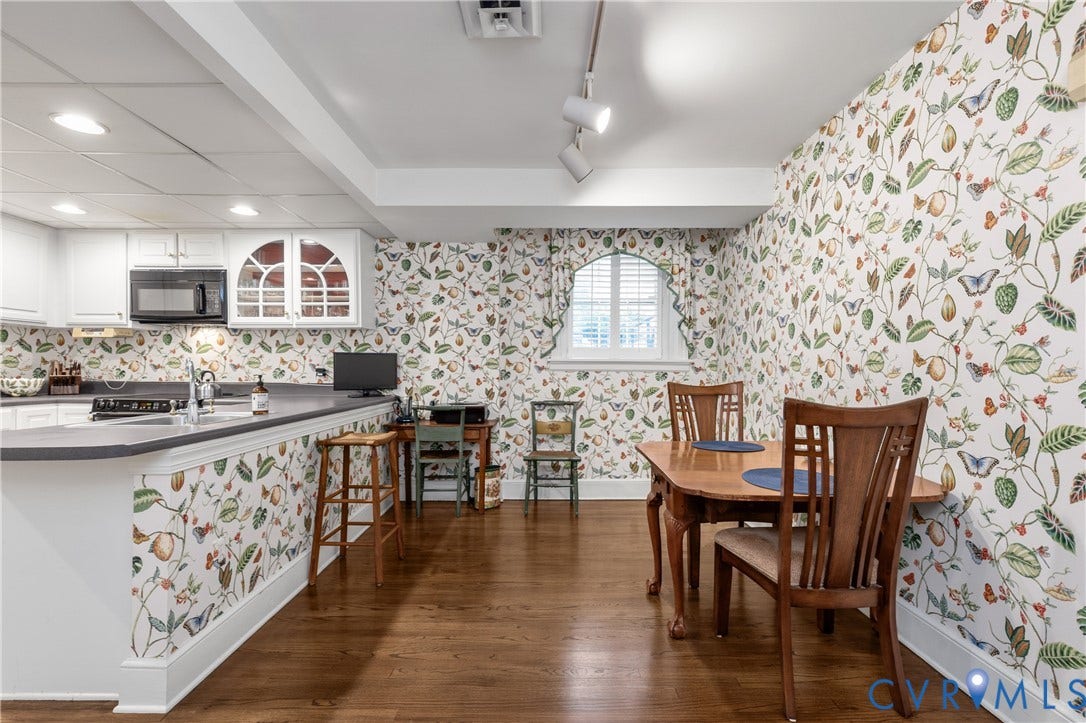 5621 Cary Street Road, #U4, Wilton, Richmond, VA 23226 Kitchen featuring wood-finish flooring, white cabinetry, dark solid-surface countertops, built-in microwave, and arched window with interior shutters