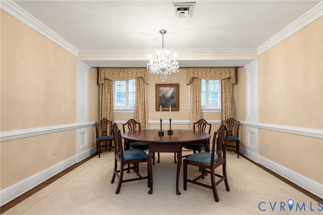 5621 Cary Street Road, #U4, Wilton, Richmond, VA 23226 Formal dining area featuring decorative wall wainscoting, crown molding, multi-pane windows with interior shutters, and a central crystal chandelier