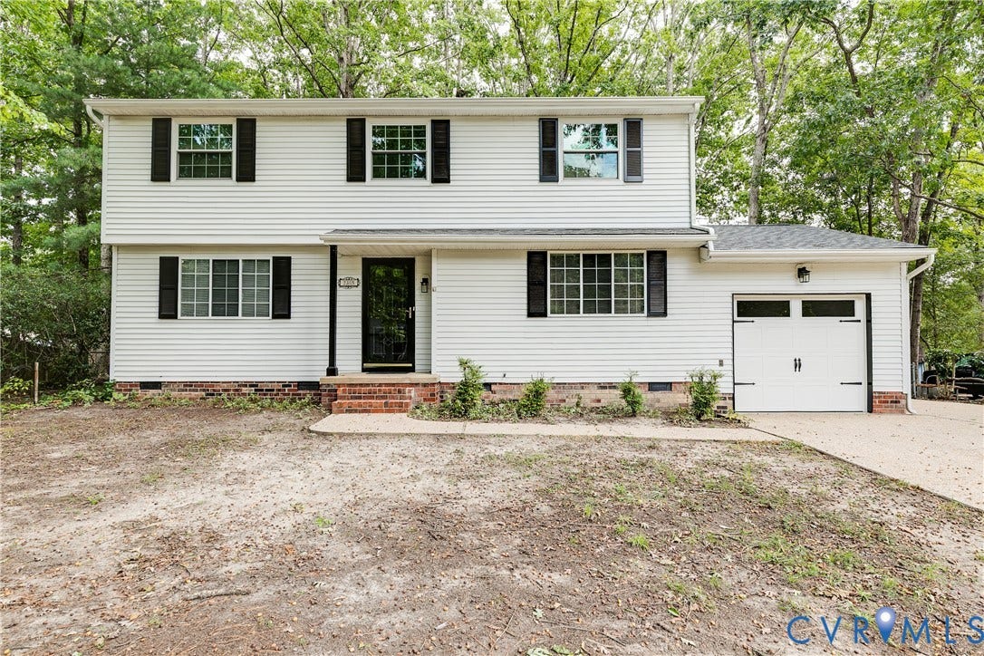 White siding exterior with black shutters, brick foundation, and a single-car garage