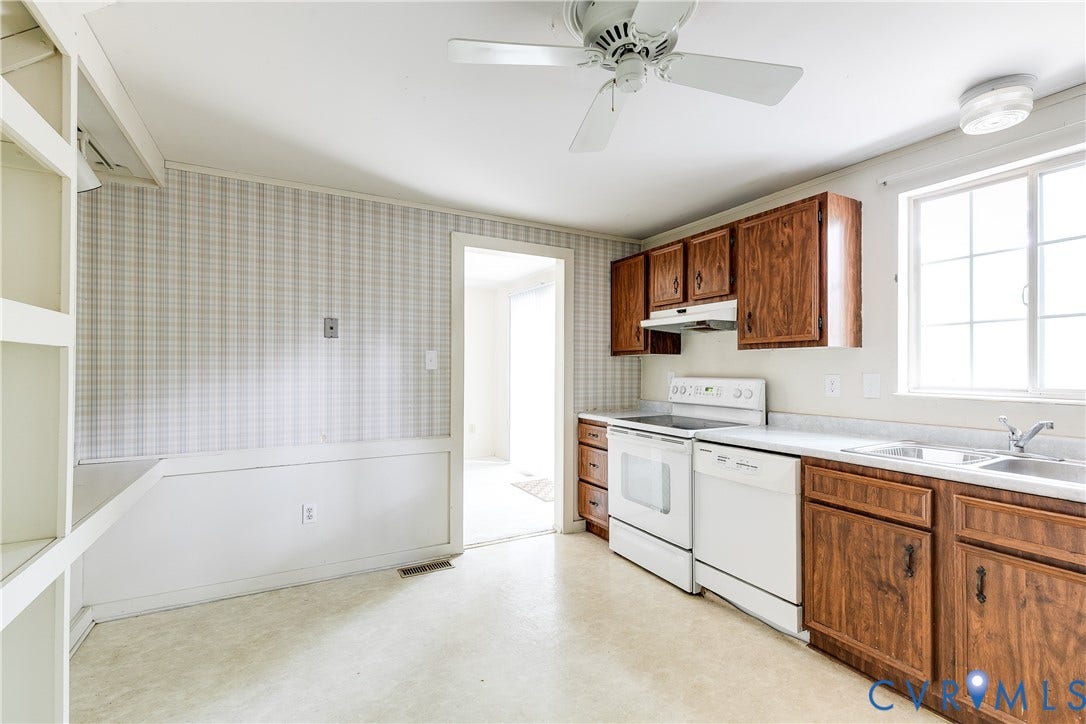 Kitchen area featuring wood-finish cabinetry, white appliances, and a double basin sink