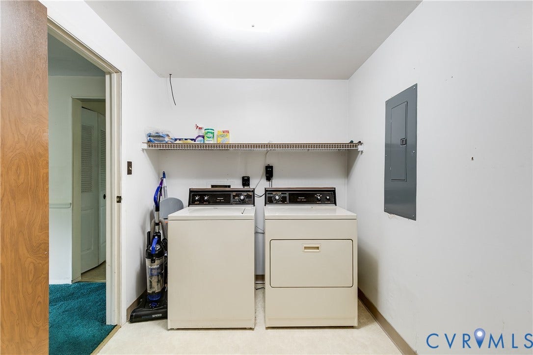 Dedicated laundry space featuring a white washer and dryer, wall-mounted shelving, and light-toned flooring