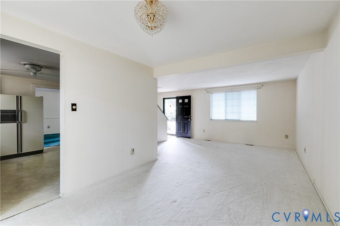 Spacious interior with neutral wall finishes and light-toned carpeting