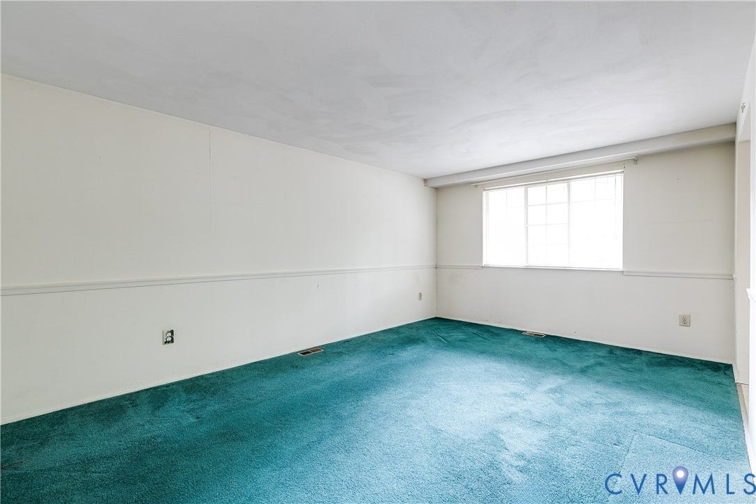 Spacious room featuring carpeting and neutral wall tones