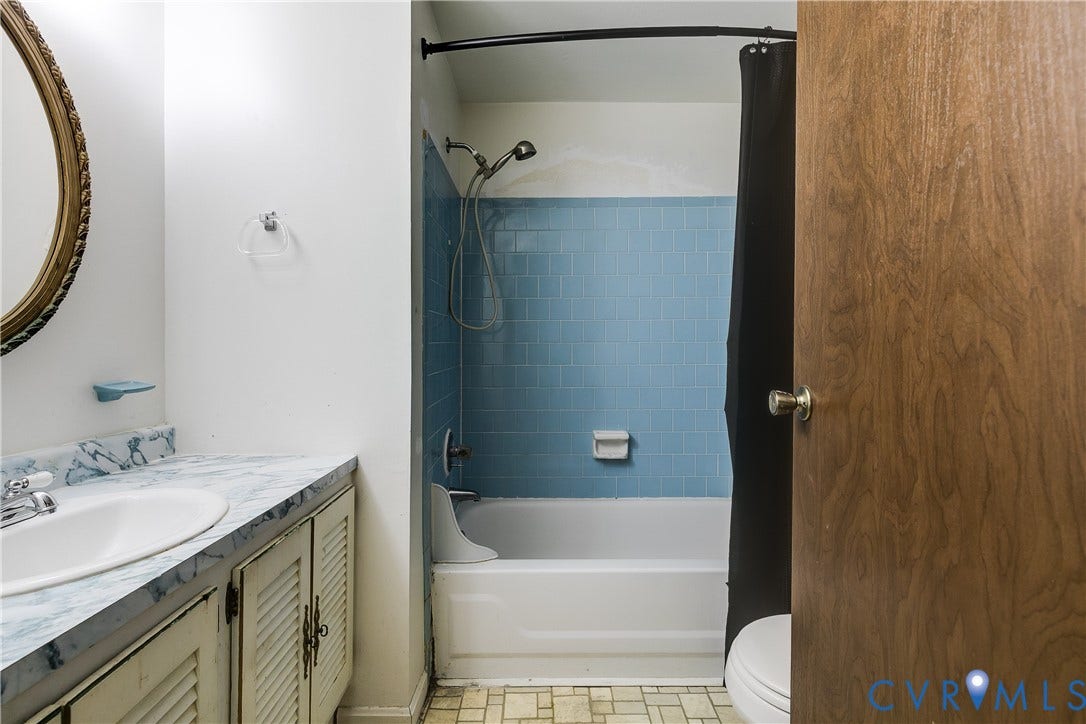Vanity with integrated sink, wood-finish cabinetry, and a blue-toned countertop
