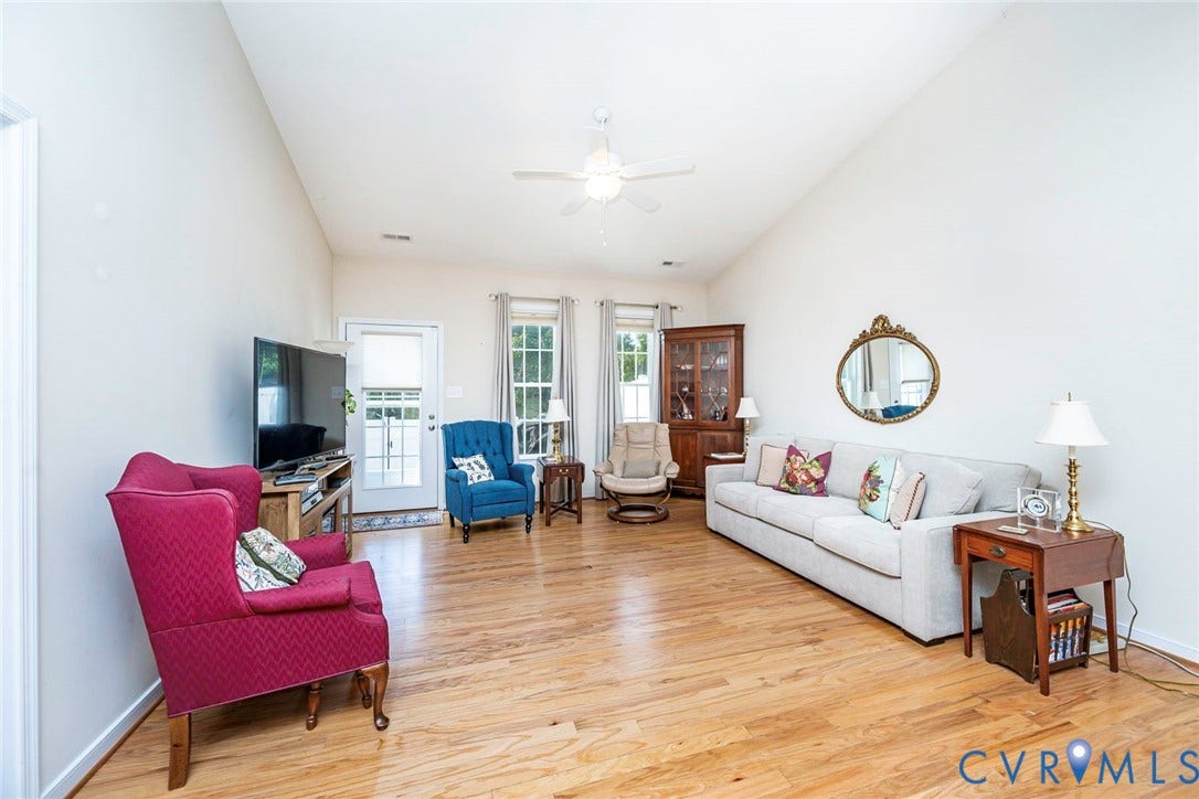 Living room with vaulted ceilings and access to rear patio and yard