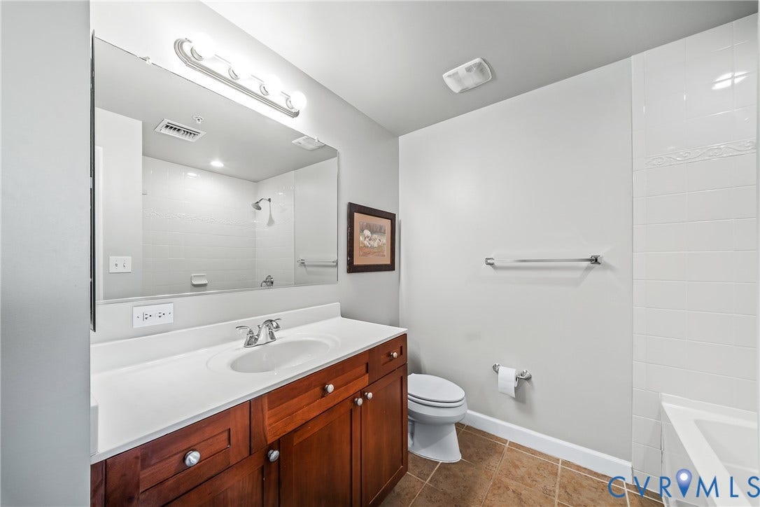 4820 Old Main Street, #503, Sky Line Condo, Richmond, VA 23231 Wood-finish vanity with an integrated sink, white countertop, and chrome faucet