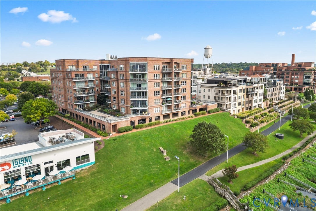 4820 Old Main Street, #503, Sky Line Condo, Richmond, VA 23231 Brick condominium building with multiple balconies, adjacent to a paved pedestrian path and green space