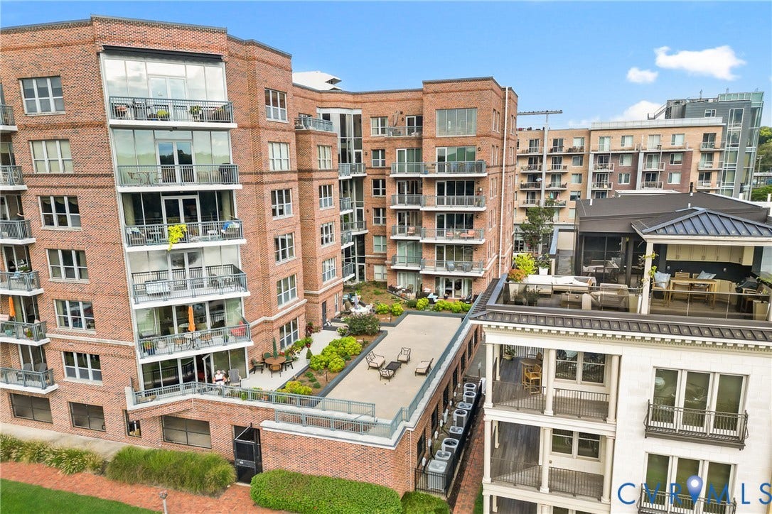 4820 Old Main Street, #503, Sky Line Condo, Richmond, VA 23231 Brick exterior construction featuring multiple balconies, a rooftop terrace, and integrated landscaping