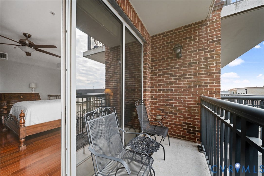 4820 Old Main Street, #503, Sky Line Condo, Richmond, VA 23231 Balcony with brick exterior wall, black metal railing, and concrete flooring