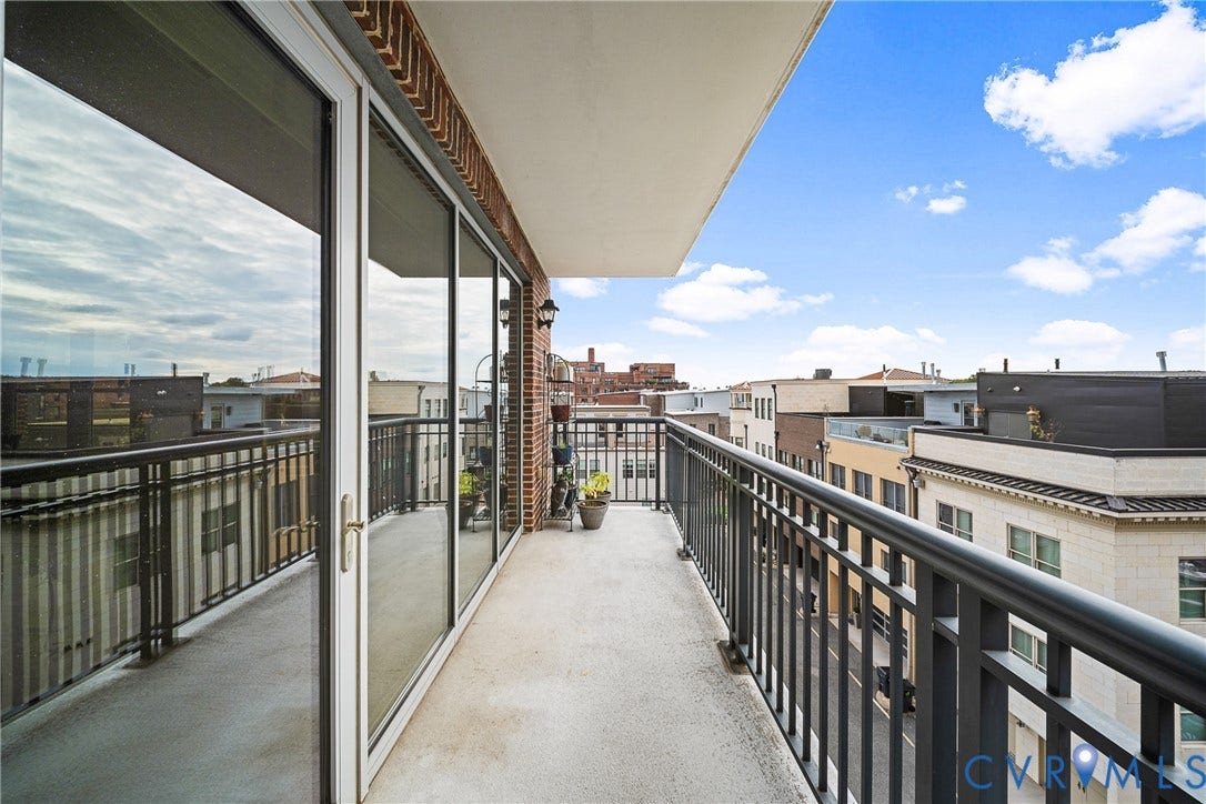 4820 Old Main Street, #503, Sky Line Condo, Richmond, VA 23231 Concrete balcony featuring a dark metal railing, full-height sliding glass doors, and brick exterior detailing