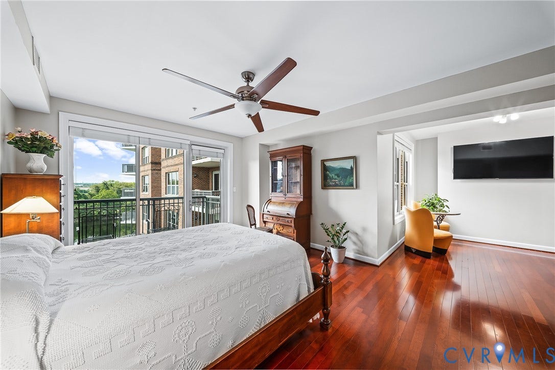 4820 Old Main Street, #503, Sky Line Condo, Richmond, VA 23231 Hardwood flooring, ceiling fan, and sliding glass door leading to a balcony with black metal railings