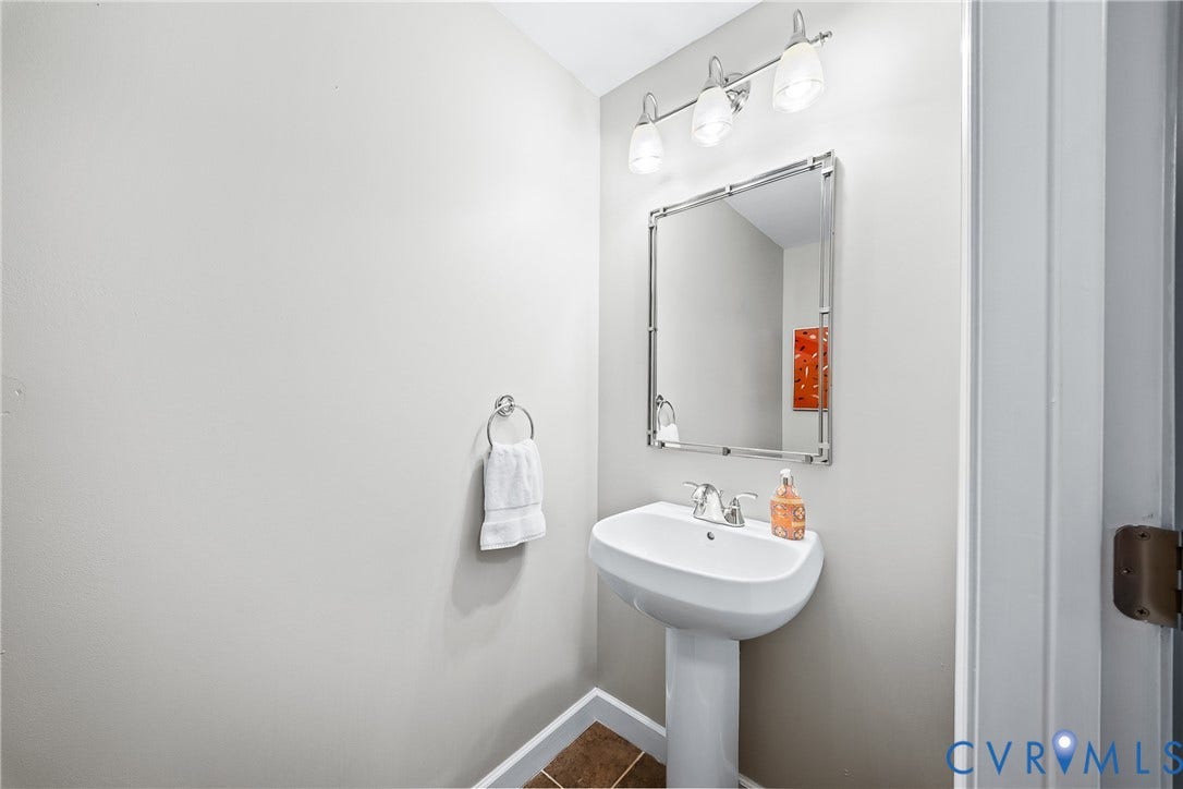 4820 Old Main Street, #503, Sky Line Condo, Richmond, VA 23231 Pedestal sink with chrome faucet, square framed mirror, and three-light vanity fixture