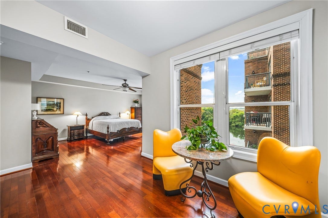 4820 Old Main Street, #503, Sky Line Condo, Richmond, VA 23231 Hardwood flooring throughout, ceiling fan, large window with white trim, and a high-rise building exterior